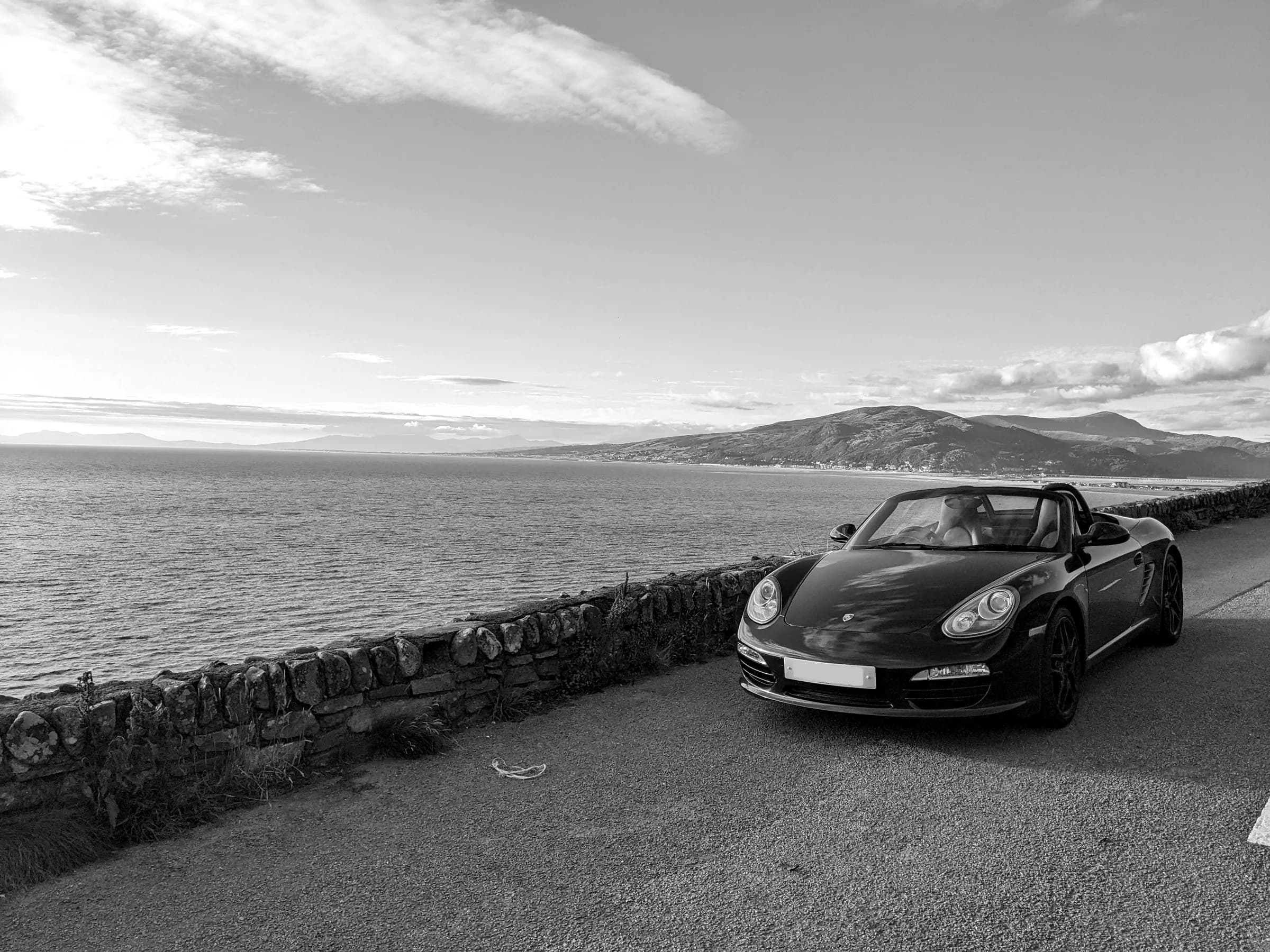 A Boxster beside the sea wall on the A493